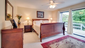 A bedroom with a wooden bed, bedside tables, a ceiling fan, and a large window with curtains. - Getaway < 9 Mi to Historic Downtown Ocala (Ocala)