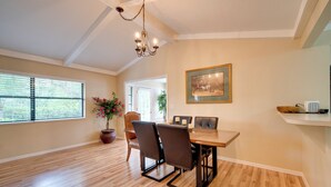 A dining area with a wooden table, chairs, a chandelier, a potted plant, and a framed picture on the wall. - Getaway < 9 Mi to Historic Downtown Ocala (Ocala)