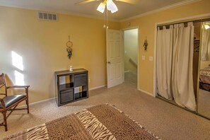 A room with a ceiling fan, a door leading to a staircase, a chair, a small cabinet, and a patterned rug. - Private Plymouth Hideaway - 13 Miles to Ann Arbor! (Canton)