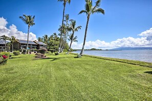 A resort with a well-maintained lawn, palm trees, and a view of the ocean. - Lush Molokai Island Oasis w/ Private Pool + Beach! (Kaunakakai)
