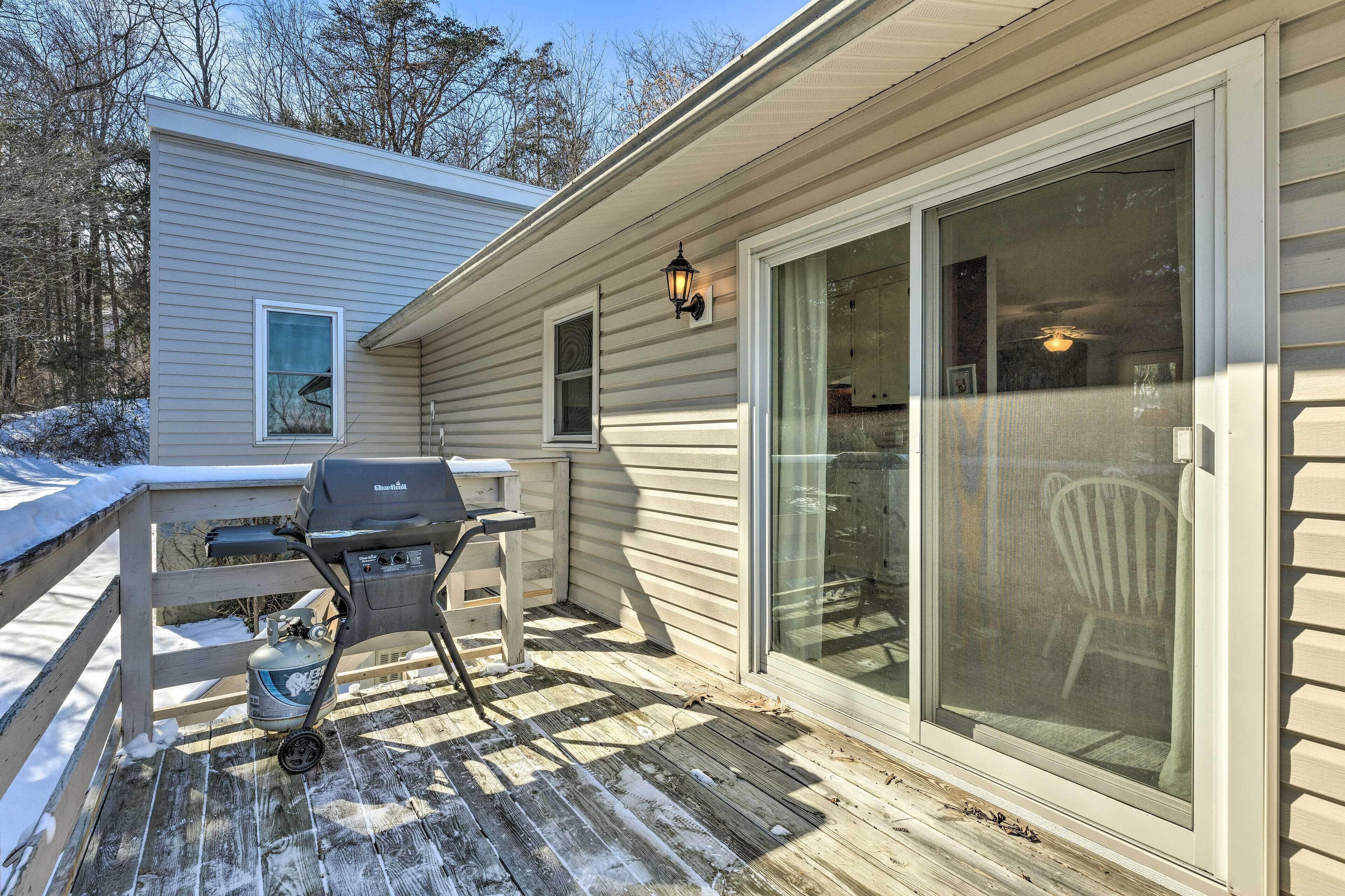 A covered deck with a grill, a sliding glass door, and a lantern.