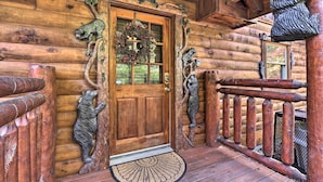 A wooden cabin entrance with a door, a wreath, and bear sculptures. - Smoky Mountain Log Cabin: 7 Mi to Gatlinburg! (Sevierville)