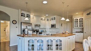 A spacious kitchen with white cabinetry, a central island, and pendant lighting. - Mcminnville Wine Country Home w/ Hot Tub + Deck (McMinnville)