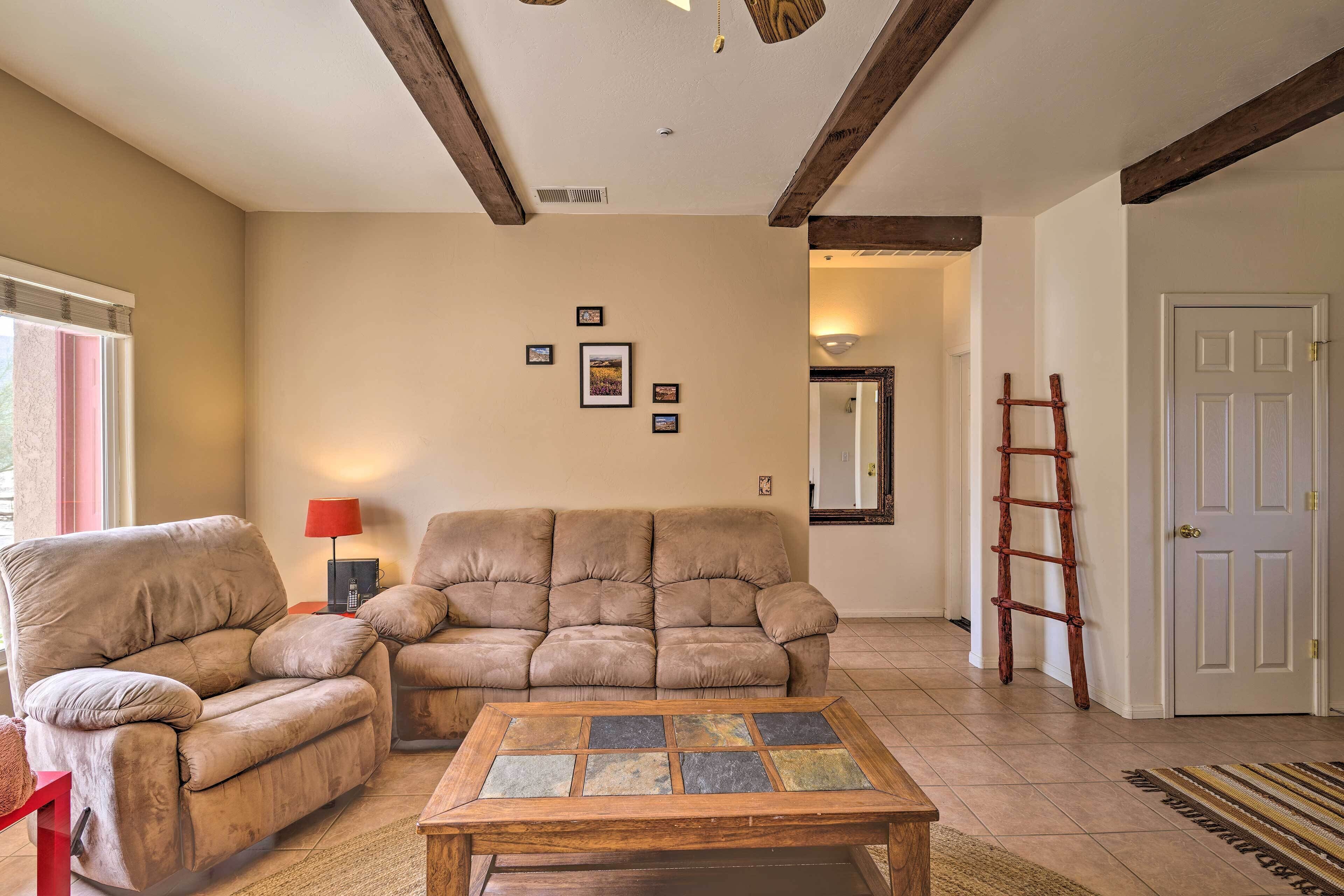 A living room with a beige sofa, a wooden coffee table, and a red lamp.