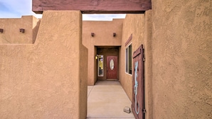 A narrow pathway leading to a door with a wooden overhang.