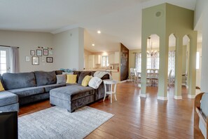 A spacious living room with a grey sectional sofa, a white side table, and a patterned rug. - Family Minnesota Vacation Rental w/ Balcony (Red Wing)