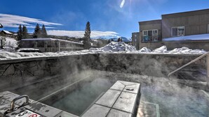 A hot spring area with a stone wall, a metal staircase, and a pool. - Hike & Bike! Mtn-view Condo 1 Block to Main St (Winter Park)