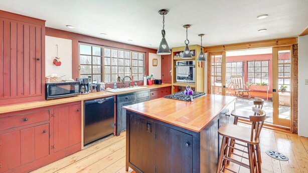 Una cocina con armarios de madera, una isla grande y una zona de bar con taburetes.