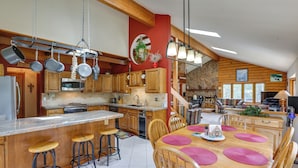 A spacious kitchen with wooden cabinets, a granite countertop, and hanging pots. - Silver Plume Mountain Haven With Views & Deck! (Silver Plume)