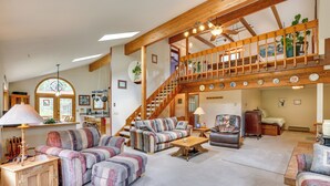 A spacious living room with a high wooden ceiling, a staircase, and a view of the outdoors. - Silver Plume Mountain Haven With Views & Deck! (Silver Plume)