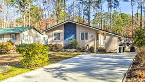 A single-story house with a front porch, a driveway, and a small yard.