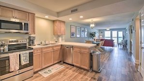 A modern kitchen with stainless steel appliances, wooden cabinets, and a central island. - Beachfront Nags Head Condo w/ Private Balcony! (Nags Head)