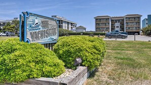 A sign for 'The Yachtman' with a clear view of modern apartment buildings in the background. - Beachfront Nags Head Condo w/ Private Balcony! (Nags Head)