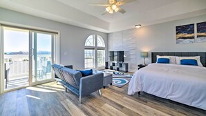 A modern bedroom with a bed, a sofa, a TV, and a balcony with a view. - Sunny PCB Home w/ Balcony: Steps to the Beach! (Panama City Beach)