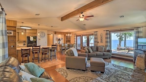A spacious living area with a leather sofa, a dining table, and a kitchen in the background. - Grand Lake Views + Fire Pit: Monkey Island Home! (Afton)
