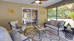 A sunroom with a ceiling fan, a sofa, a coffee table, and a patterned rug. - 8 Mi to Rainbow Springs: Dunnellon Area Home! (Citrus Springs)