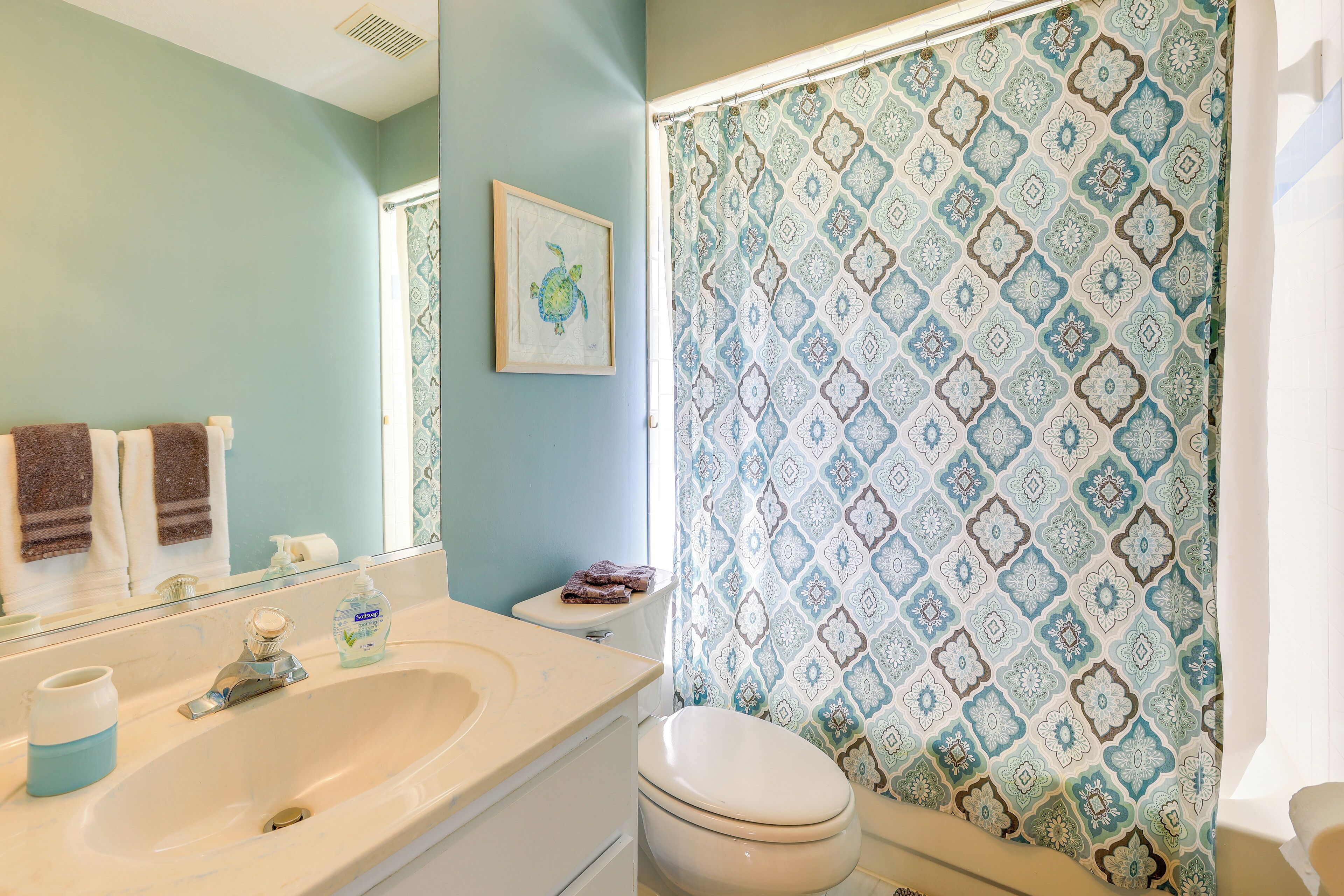 A bathroom with a sink, toilet, and shower curtain.
