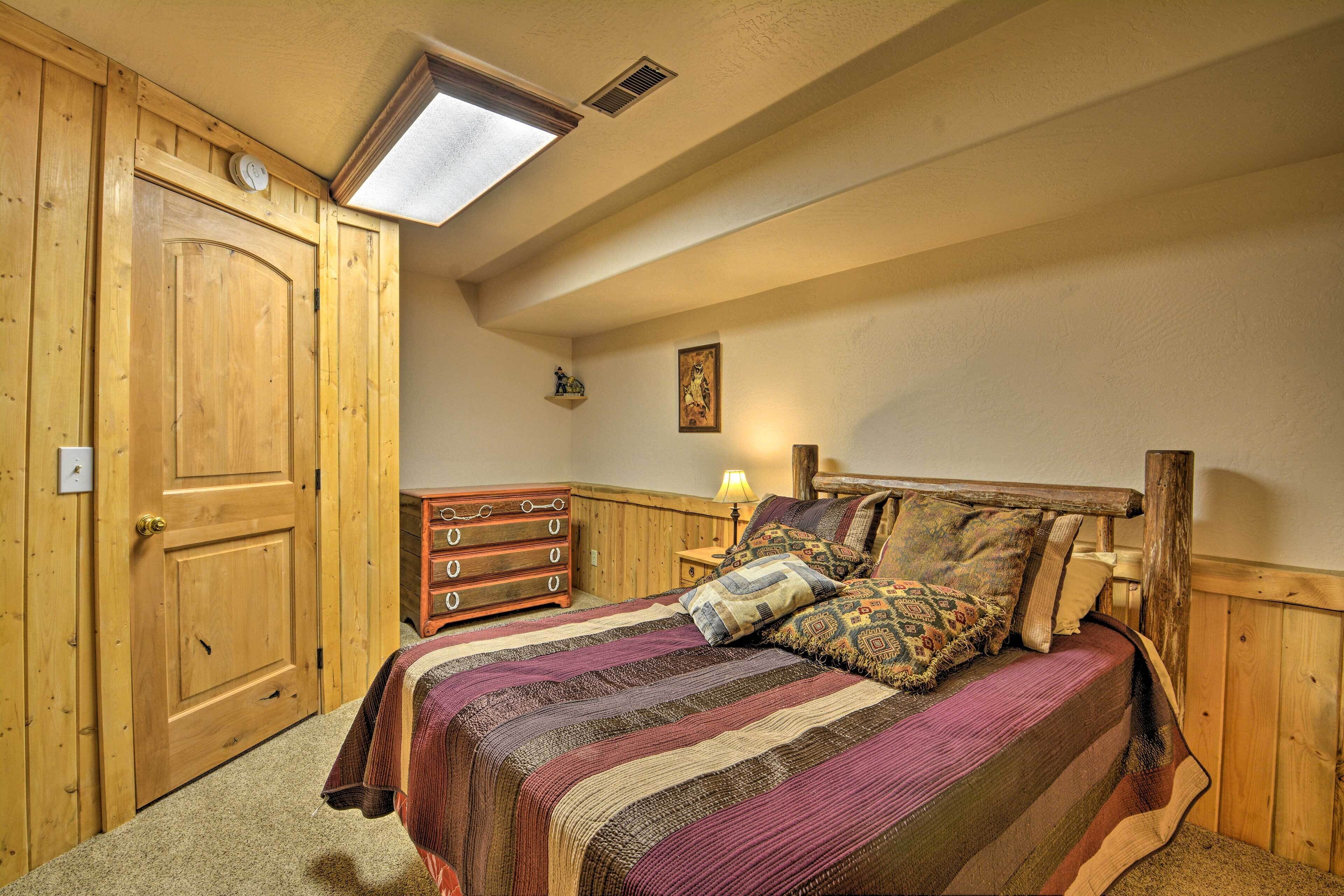 Ein Schlafzimmer mit Holztür, Kommode, Bett mit Streifenmuster und einem Oberlicht.