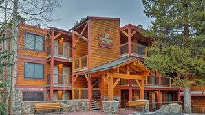 Un bâtiment à étages, de style chalet, avec une façade en bois, une enseigne indiquant « Tannermalm, au bord de la rivière », et une entrée en pierre.
