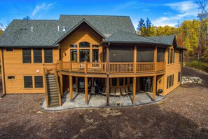 A two-story wooden house with a balcony and a covered patio area. - Lakefront Retreat at Giants Ridge: Golf, Hike, Ski (Aurora)