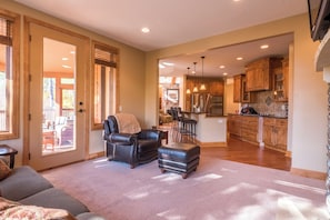 A spacious living area with a leather sofa, ottoman, and a dining area with bar stools. - Lakefront Retreat at Giants Ridge: Golf, Hike, Ski (Aurora)