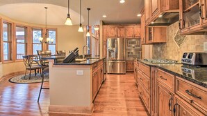 A spacious kitchen with wooden cabinets, stainless steel appliances, and a central island. - Lakefront Giants Ridge Retreat Near Ski & Golf! (Aurora)