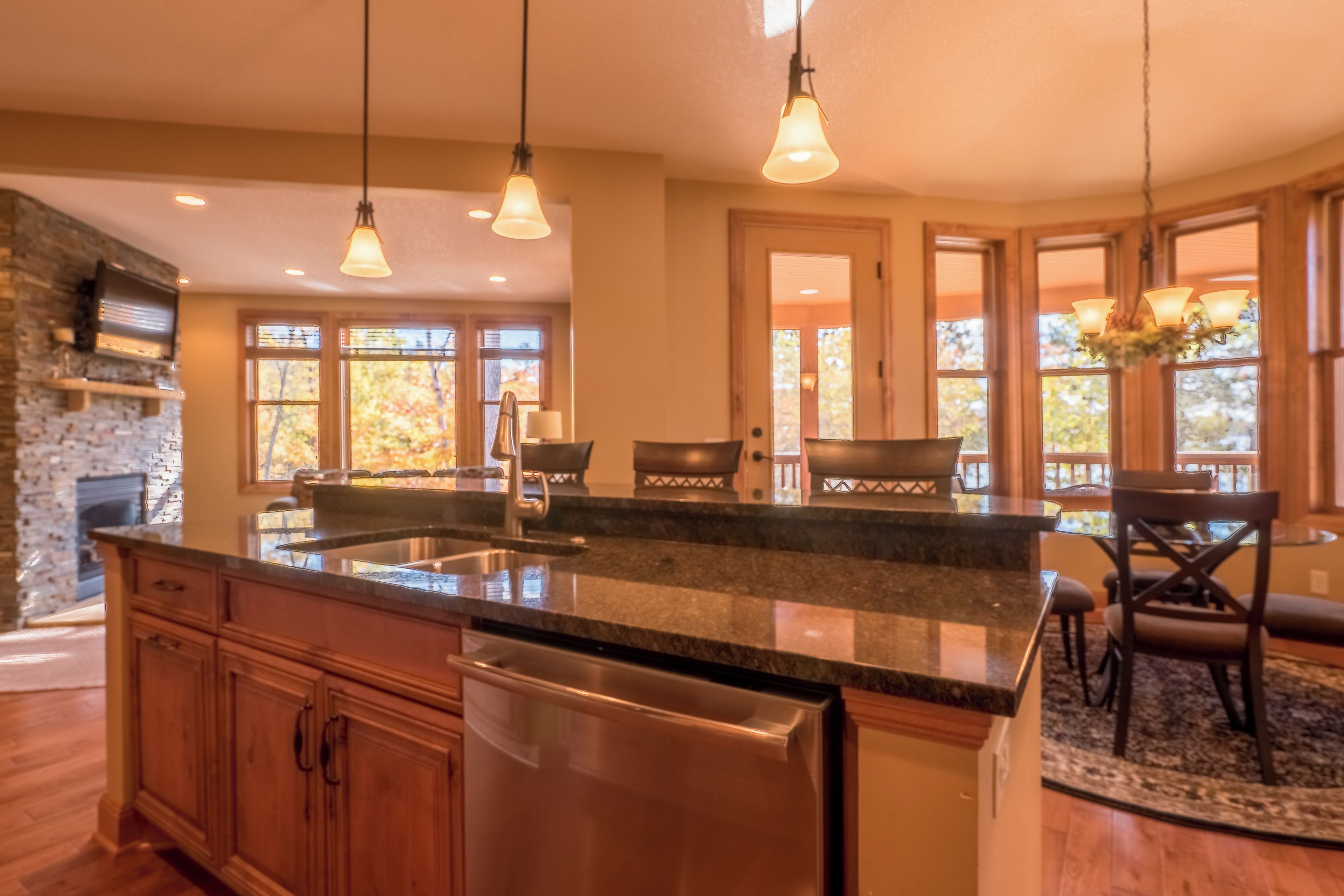 A spacious kitchen with a large island, stainless steel appliances, and a stone backsplash.
