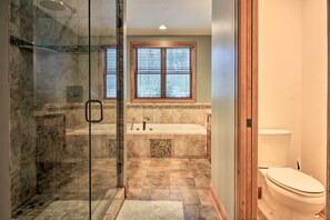 Bathroom features a bathtub, glass-enclosed shower, and standard toilet.
