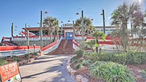 A beachfront restaurant with a red and white facade, a blue entrance, and a brick pathway leading to the entrance. - Beach Retreat in Jacksonville: Pet/family-friendly (Jacksonville Beach)