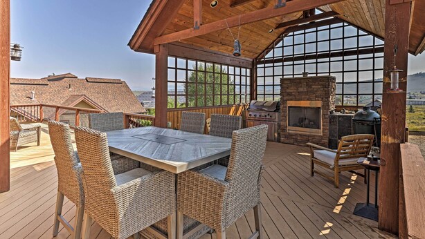 A covered outdoor patio with a dining table, wicker chairs, and a grill area. - Golf, Ski & Hike: Luxe Group Getaway in Granby! (Granby)