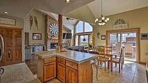 A spacious kitchen with a large island, wooden cabinets, and a stone accent wall. - Golf, Ski & Hike: Luxe Group Getaway in Granby! (Granby)