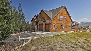 A large wooden house with a stone foundation, a garage, and a covered porch. - Golf, Ski & Hike: Luxe Group Getaway in Granby! (Granby)