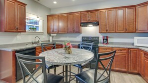 A kitchen with wooden cabinets, a marble island, and a built-in oven.