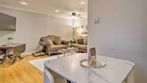 A modern living room with a marble coffee table, leather sofa, and a ceiling fan. - Couples Hub Near Metlife, Walk to Public Transit! (Hoboken)