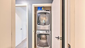 A compact laundry room with two stacked washing machines and a dryer, enclosed by a door with a handle. - 2 Blocks to Skiing & Mtb: Angel Fire Condo (Angel Fire)