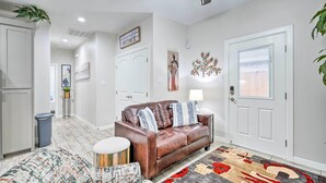 A living room with a brown leather sofa, a patterned armchair, and a decorative rug.