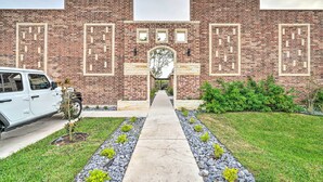A brick building with a central archway and a pathway leading to it.