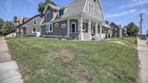 A two-story house with a front porch, a covered entryway, and a sloped roof.
