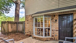 A house with a brick exterior, a large window, and a dark door. - Cozy Ruston Townhome < 1 Mi to Louisiana Tech (Ruston)