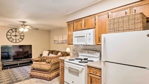 A kitchen with wooden cabinets, a microwave, a stove, and a refrigerator. - Cozy Ruston Townhome < 1 Mi to Louisiana Tech (Ruston)
