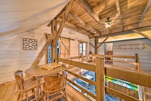 A wooden interior with a dining area, a ceiling fan, and a view of an outdoor pool.