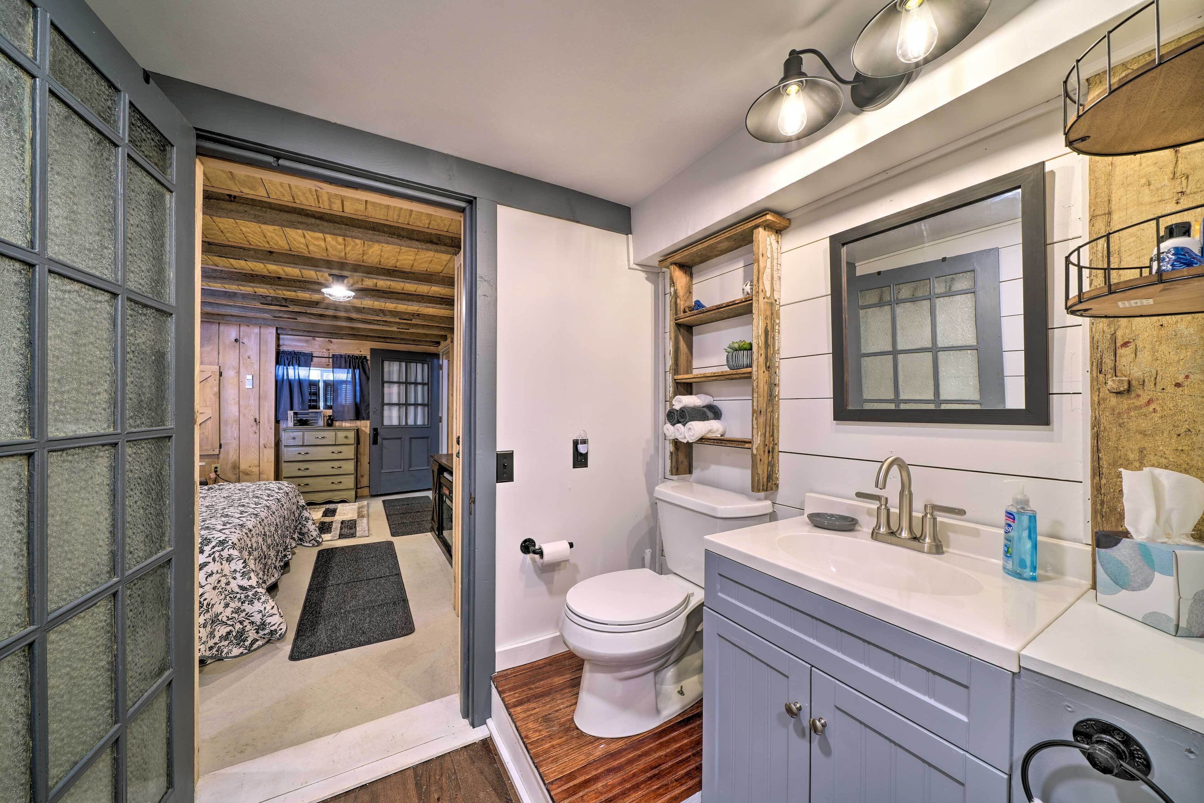 Un baño moderno con tocador de madera, un espejo grande y un inodoro.