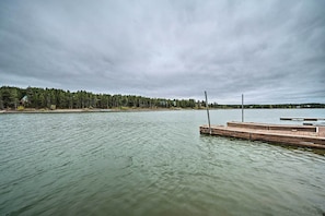 A calm lake with a wooden dock extending into the water. - 2 Cozy Island Park Cabins w/ Near the Lake! (Island Park)