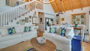 A spacious living room with white sofas, a wooden coffee table, and a staircase leading to an upper level. - Beautiful Lake Keowee Home w/ Boat Dock & Fire Pit (Seneca)