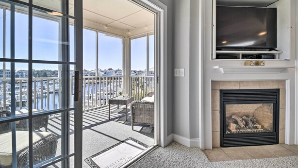 A balcony with wicker furniture, a fireplace, and a TV mounted above it.