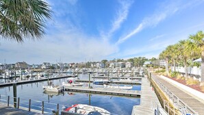 A marina with multiple docks, boats, and a wooden walkway.