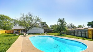 A backyard with a swimming pool, a covered patio, and a wooden fence. - Home w/ Game Room & Pool: Wichita Falls Retreat (Wichita Falls)