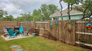 Ein Garten mit Holzlattenzaun, Gartenmöbeln und Dekorationselementen.