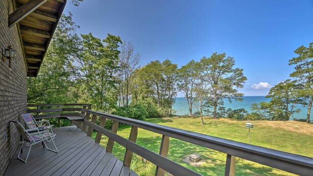 A wooden deck with a view of a grassy area and a body of water. - Brocton Escape: Skiing, Snowtubing, Hiking! (Brocton)