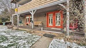 A wooden cabin with a porch, red doors, and a bench. - Primitive Goshen Pine Lodge With Fireplace! (Middlebury)